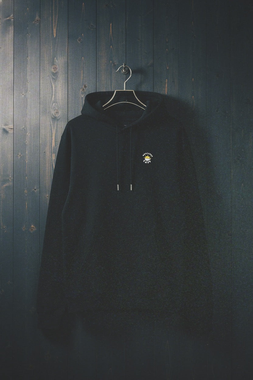 Black hoodie with a logo on a hanger against a dark wooden wall